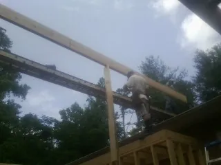 Carpenter setting a ridge beam over a new addition frame — Ice Dam Removal by Roofing Brothers in Oconomowoc