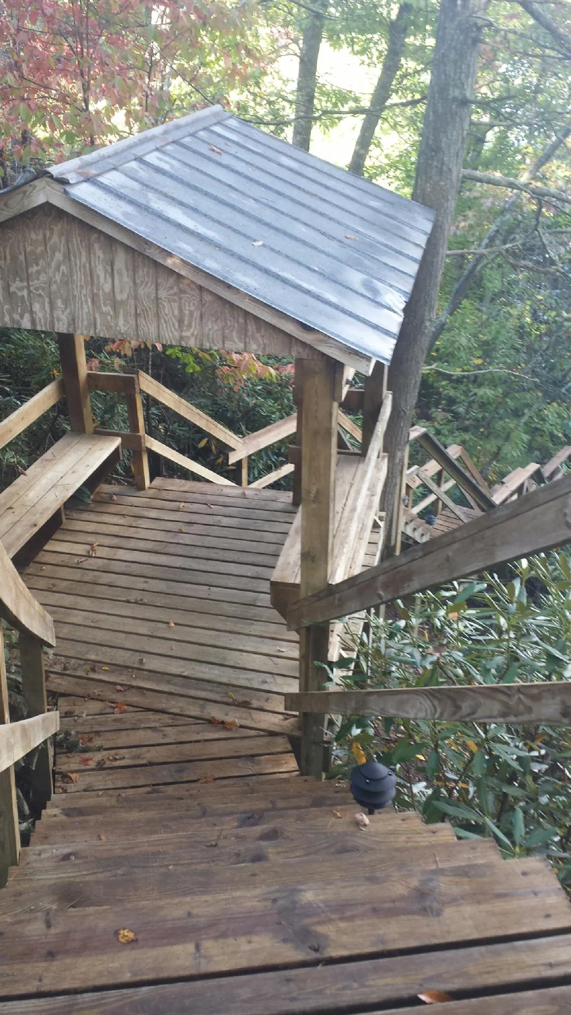 Metal roofed shelter over wooden steps on a wooded walkway — Skylight Repair & Installation work by our crew in Oconomowoc