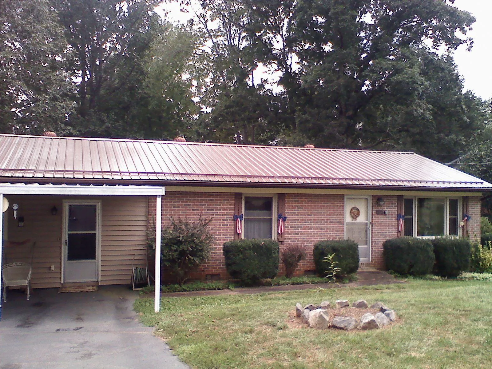 Bronze metal roof and carport on a brick ranch home — Roof Repair work by our crew in Oconomowoc